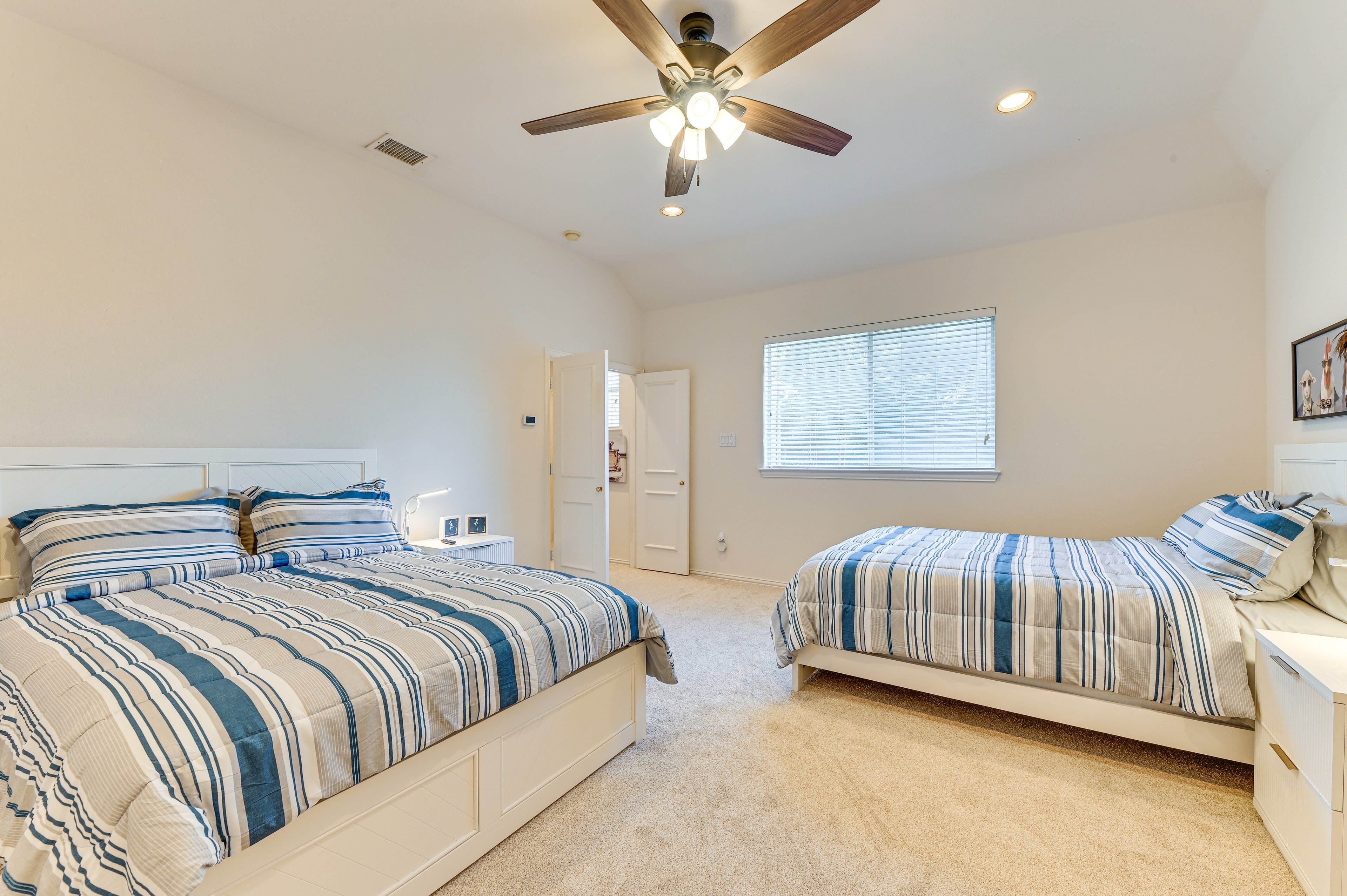 Shared Bedroom 5 — two beds with blue striped bedding, recliner, desk, and Smart TV