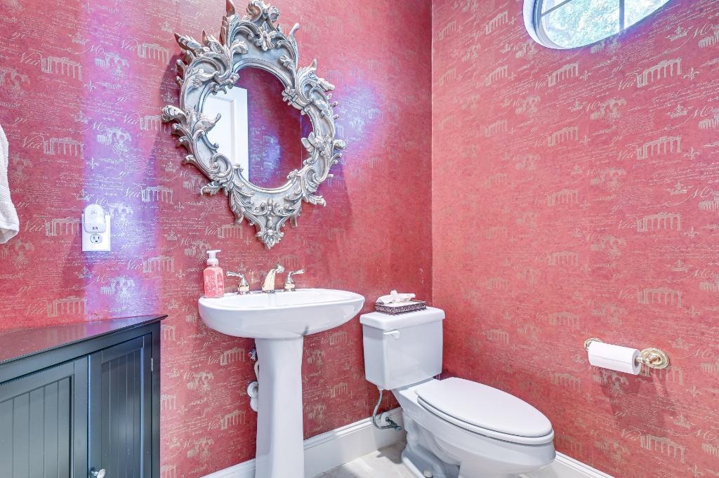 Private Suite Bedroom 2 — powder room with ornate mirror and coral wallpaper