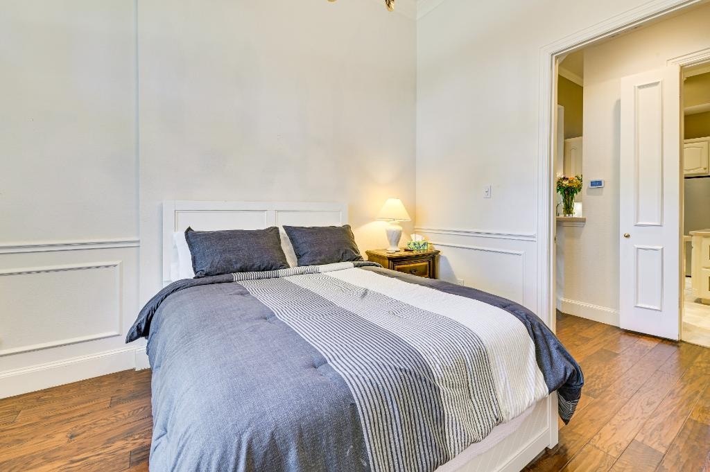 Private Suite Bedroom 2 — queen bed with wainscoting and warm lighting