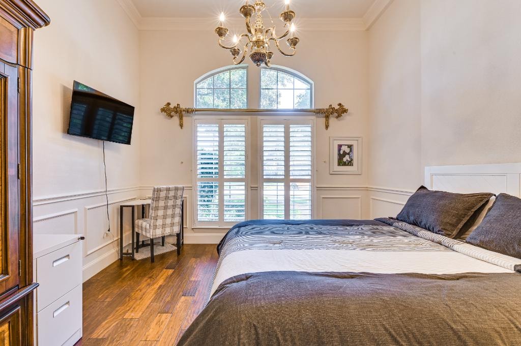 Private Suite Bedroom 2 — elegant room with chandelier and arched window