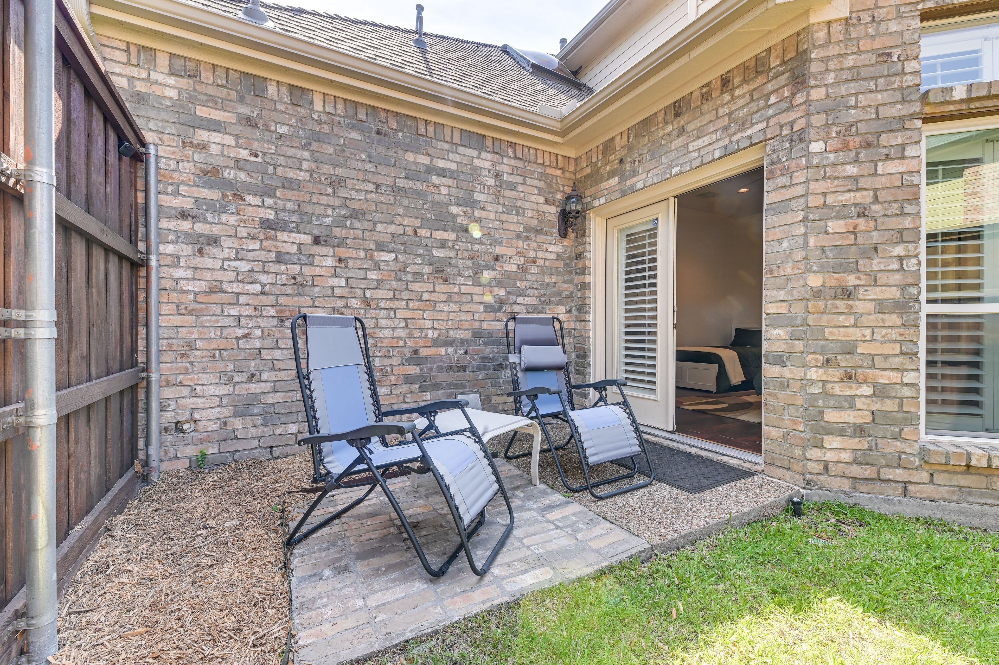 Premier Suite Bedroom 3 — private brick patio with zero-gravity lounge chairs